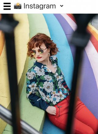 Screenshot of my Instagram feed, showing a model lounging under the sun on some rainbow-painted stairs; Photo by Donna Murray Photography