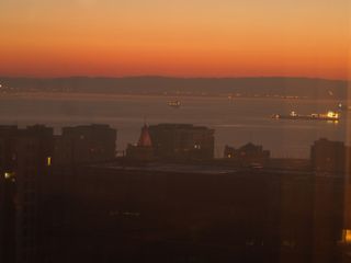Boats in San Francisco Bay, at sunrise. Oakland can be seen in the background, across the water.